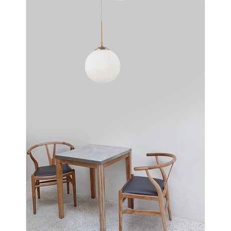 Athena Glas-Pendellampe Ø 25cm über einem Tisch mit Holzstühlen in modernem Essbereich.