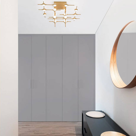 Atomo LED éclairage de plafond en métal doré dans un espace moderne avec des murs gris et un miroir élégant.
