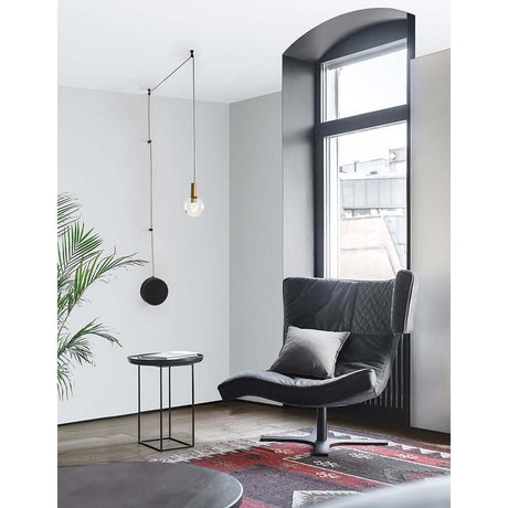 Moderne Einrichtung mit Belar LED Wand- & Hängelampe Goldfarben über einem stilvollen Sessel und Tisch.