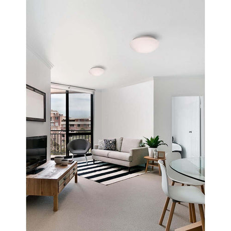 Brest Bad Deckenlampe Opal-Weiß in modernem Wohnzimmer mit Sofa und Tisch.
