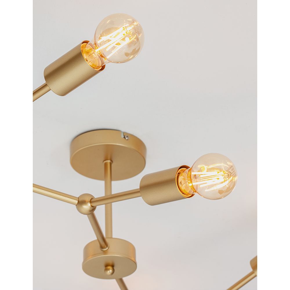 Nahaufnahme der Calisto Deckenleuchte mit messingfarbenen Metallarmen und dekorativen Glühbirnen.