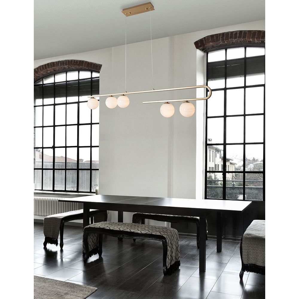 Moderne Cantona Hängelampe in Messingfarben und Weiß über einem Esstisch in heller Wohnung.