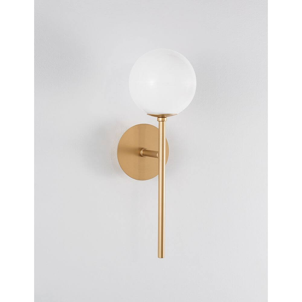Cantona Glas-Wandlampe Messing, Weiß an der Wand, modernes Design mit weißer Glaskuppel und messingsfarbener Halterung.