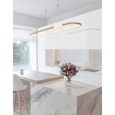 Suspension Celia LED 100 cm dans une salle à manger moderne au-dessus d’un îlot de cuisine en marbre avec des fleurs fraîches.