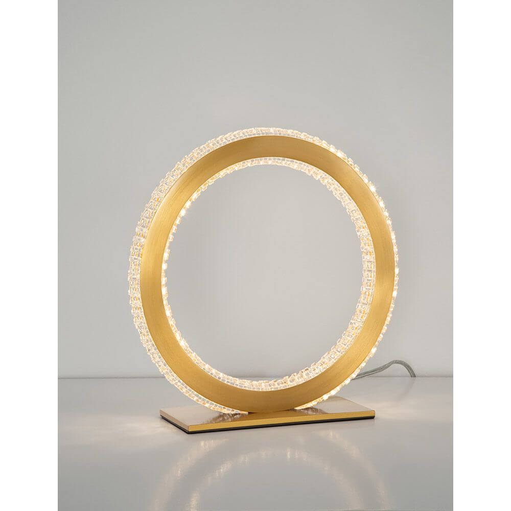 Cilion LED Tischlampe Ø 25cm Messing, Gold auf einem Tisch in modernem Design.