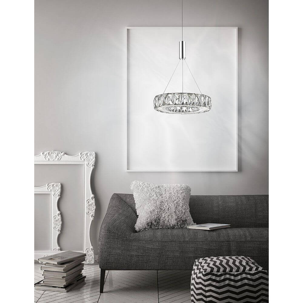 Moderne Wohnaufnahme mit Corona LED Pendelleuchte Ø 27cm Kristall über einem eleganten Sofa.