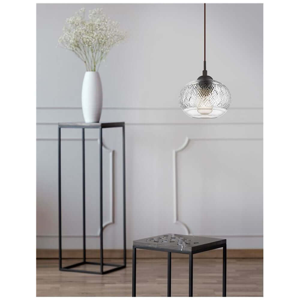 Devon Glas-Pendellampe Braun, Klar über einem Tisch mit schwarzem Metallgestell und blumiger Dekoration.