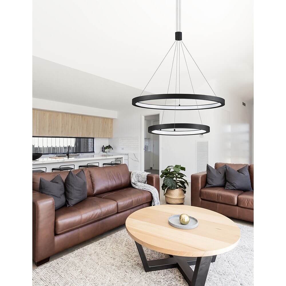 Empatia LED Hängeleuchte Ø 60cm 2 Ringe über modernem Wohnzimmer mit braunen Ledersofas, minimalistische schwarze Aluminiumringe, warmweißes LED-Licht