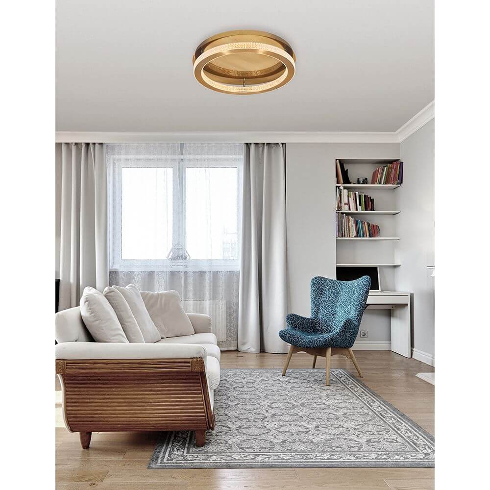 Fiore LED Deckenlampe Antik-Gold in modernem Wohnraum mit bequemer Couch und stilvollem Stuhl.