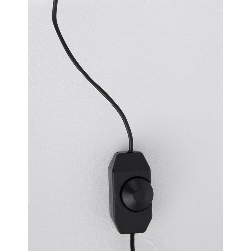Gabbia LED Würfel Tischlampe mit schwarzem Dimmer und Kabel an einer Wand.