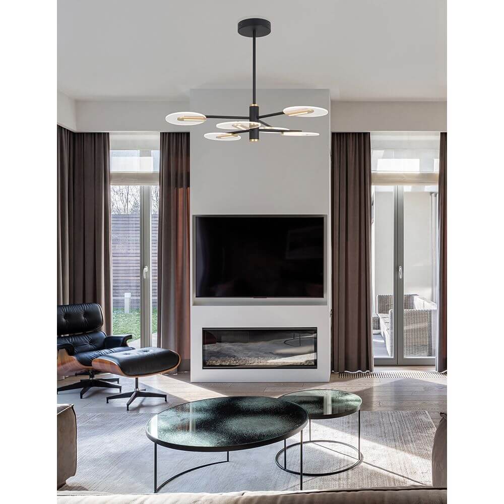 Genti LED Hängelampe Schwarz, Gold in modernem Wohnzimmer über einem Tisch.