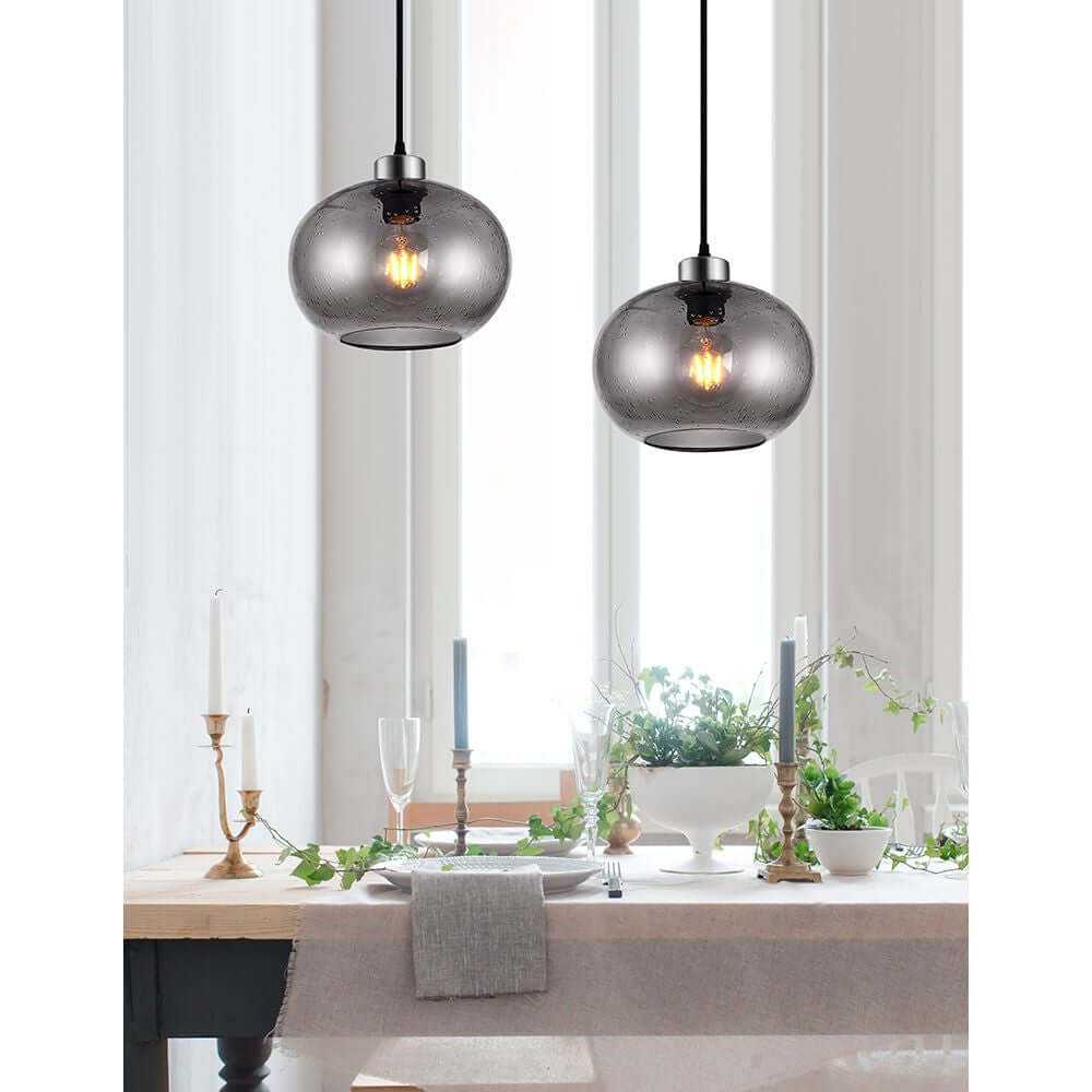 Jade Hängelampe aus Geblasenem Glas über einem eleganten Esstisch mit Kerzen und Pflanzen.