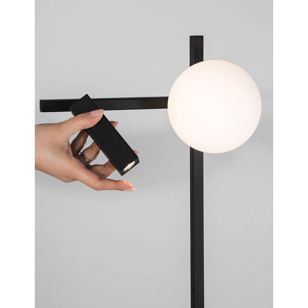 Joline LED Stehleuchte 2-flammig Sandig-Schwarz mit Hand, die eine schwarze Lampe hält.