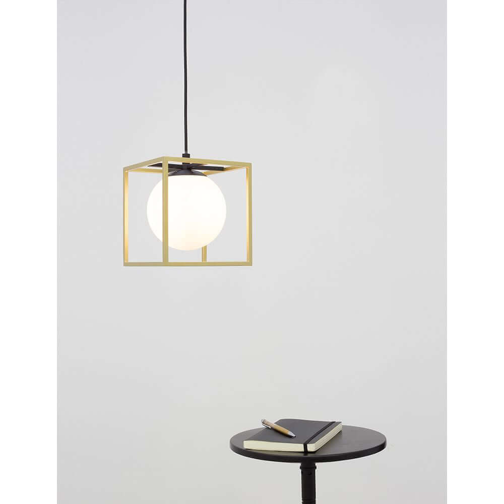 Juliet Hängelampe Würfel Ø 40cm Messing über einem Tisch mit Notizbuch, modernes Design, elegante Lichtquelle