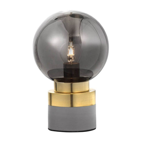 Juliet Glas-Tischlampe Gold auf einem modernen Tisch, elegante Glaskugel und goldene Basis.