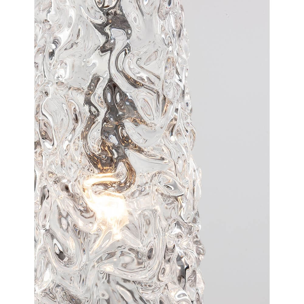 Detailaufnahme der Nova Luce Kovac Pendellampe Stahl Gold mit gläserner Oberfläche und Lichtquelle.