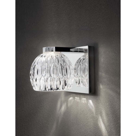 Lara Wandlampe Glas Chrom an einer Wand montiert mit eleganter Glas- und Chrom-Optik.