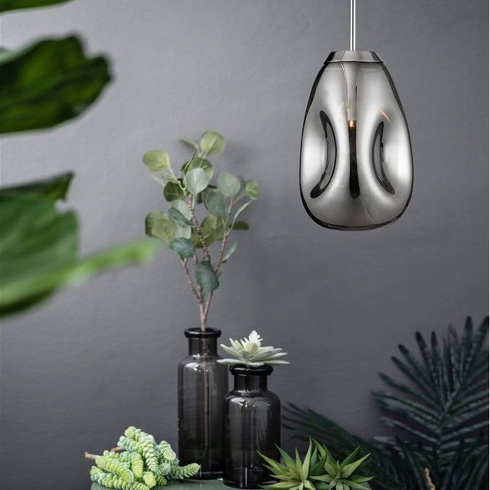 Lava Hängeleuchte mundgeblasenes Glas über Pflanzenarrangement im modernen Interieur.