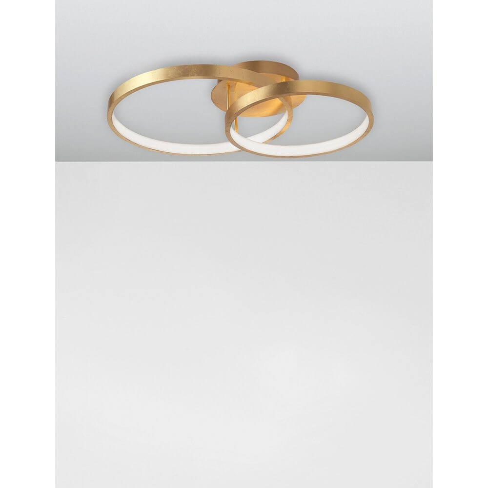 Leon LED Deckenleuchte Metall Gold mit zwei ineinander verschlungenen Kreisen aus Blattgold-beschichtetem Aluminium.