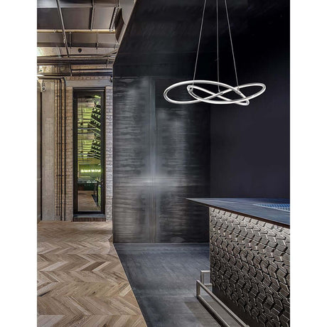 Martino LED Hängeleuchte Ø 60cm Chrom in modernem Raum mit Holzfußboden und dunkler Wand.