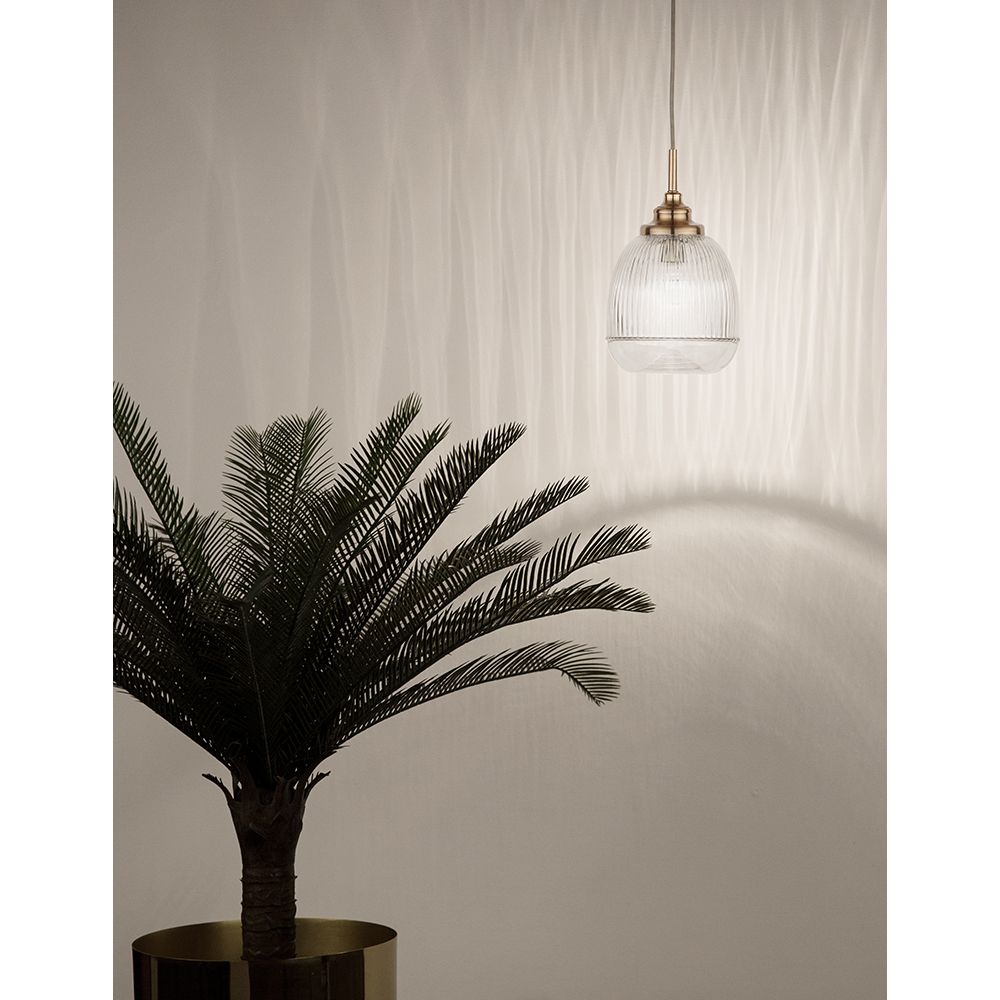 Mond Pendellampe Ø 15cm aus Glas in Gold, beleuchtet modernen Raum mit stilvollem Pflanzenarrangement.