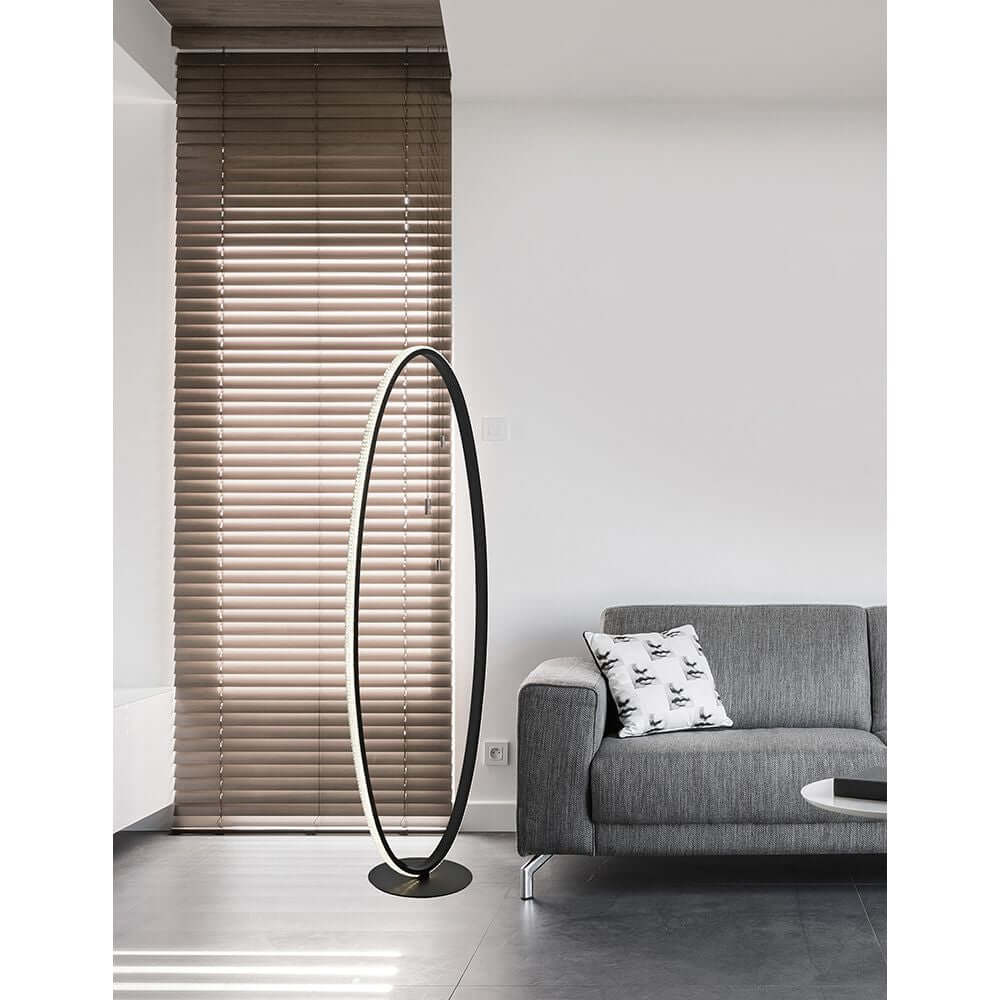 Nager LED Stehleuchte Ring 125cm Sandig-Schwarz in modernem Wohnzimmer mit grauer Couch.