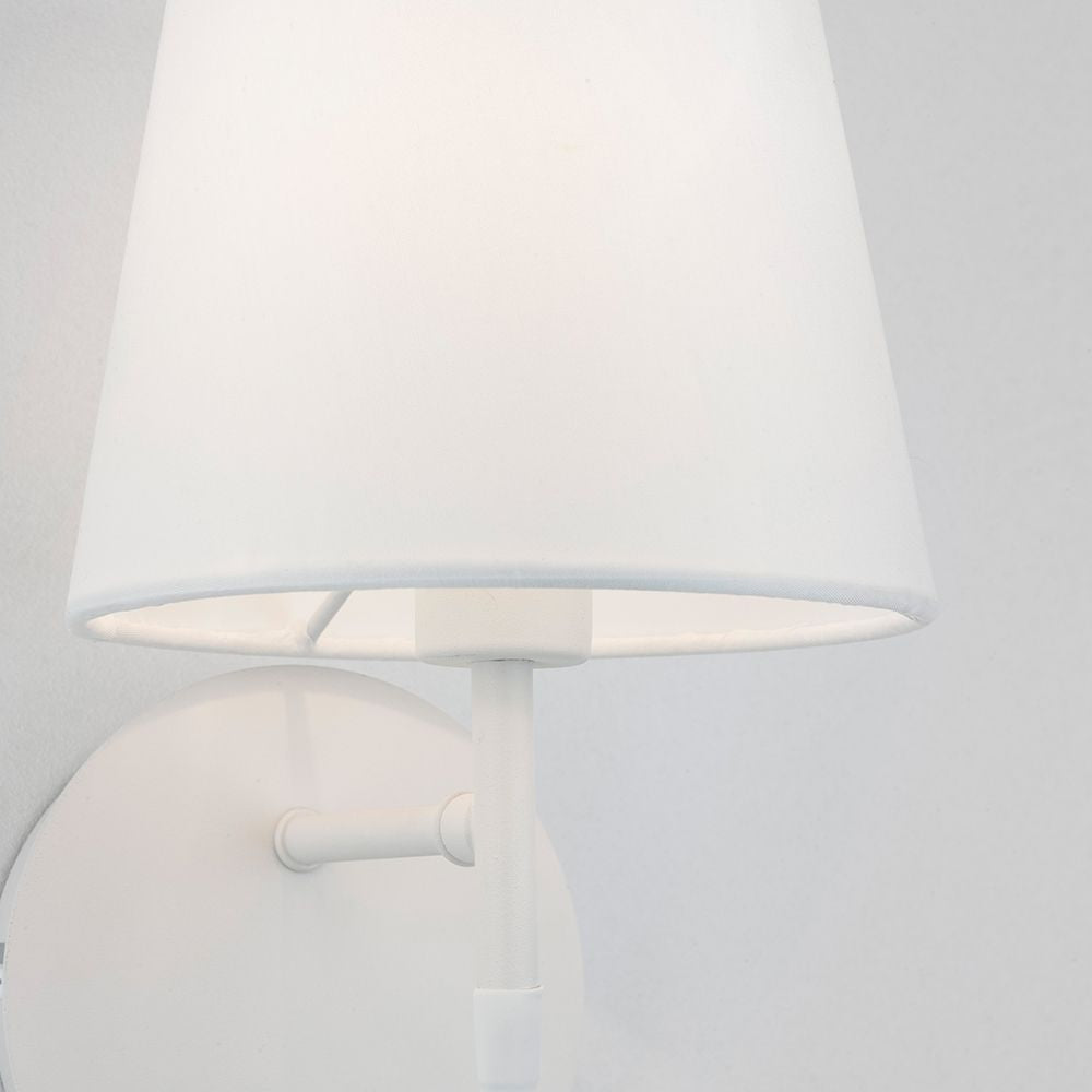 Nia Wandleuchte mit weißem Stoffschirm und eleganter Aluminiumhalterung.