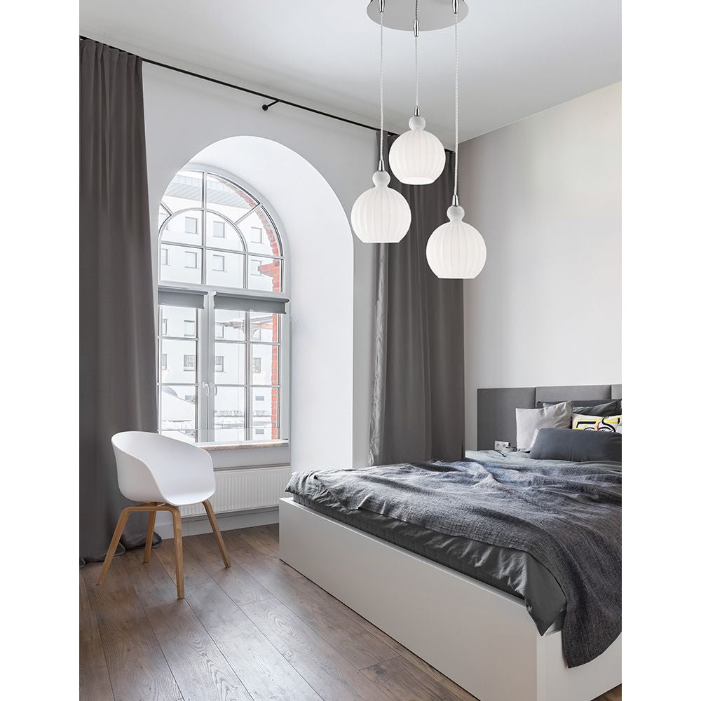 Moderne Odell Hängeleuchte 3-flammig Opal-Weiß im Schlafzimmer mit grauen Vorhängen und stylischem Bett.
