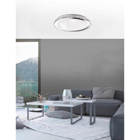 Plafonnier Nova Luce Palermo cristal K9 chromé dans un salon moderne avec vue sur les montagnes.