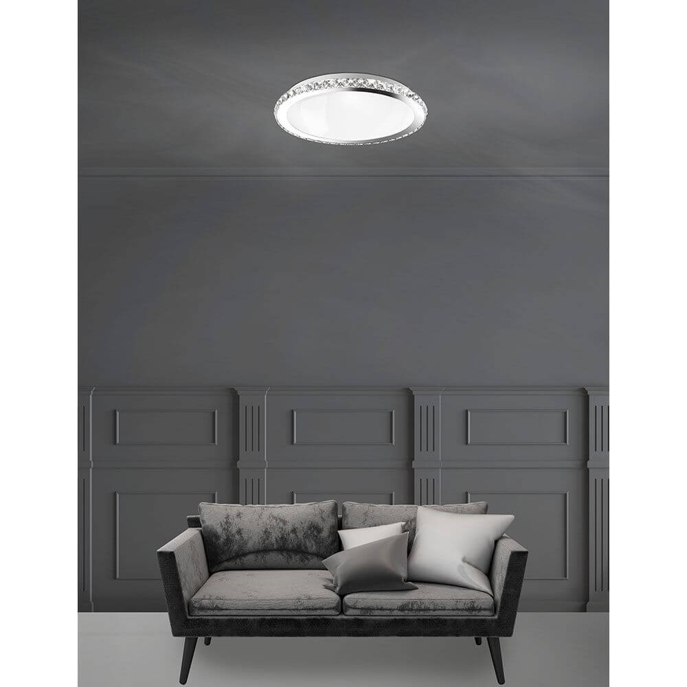 Nova Luce Palermo Deckenleuchte K9 Kristall Chrom unter einem modernen Raum mit Sofa.