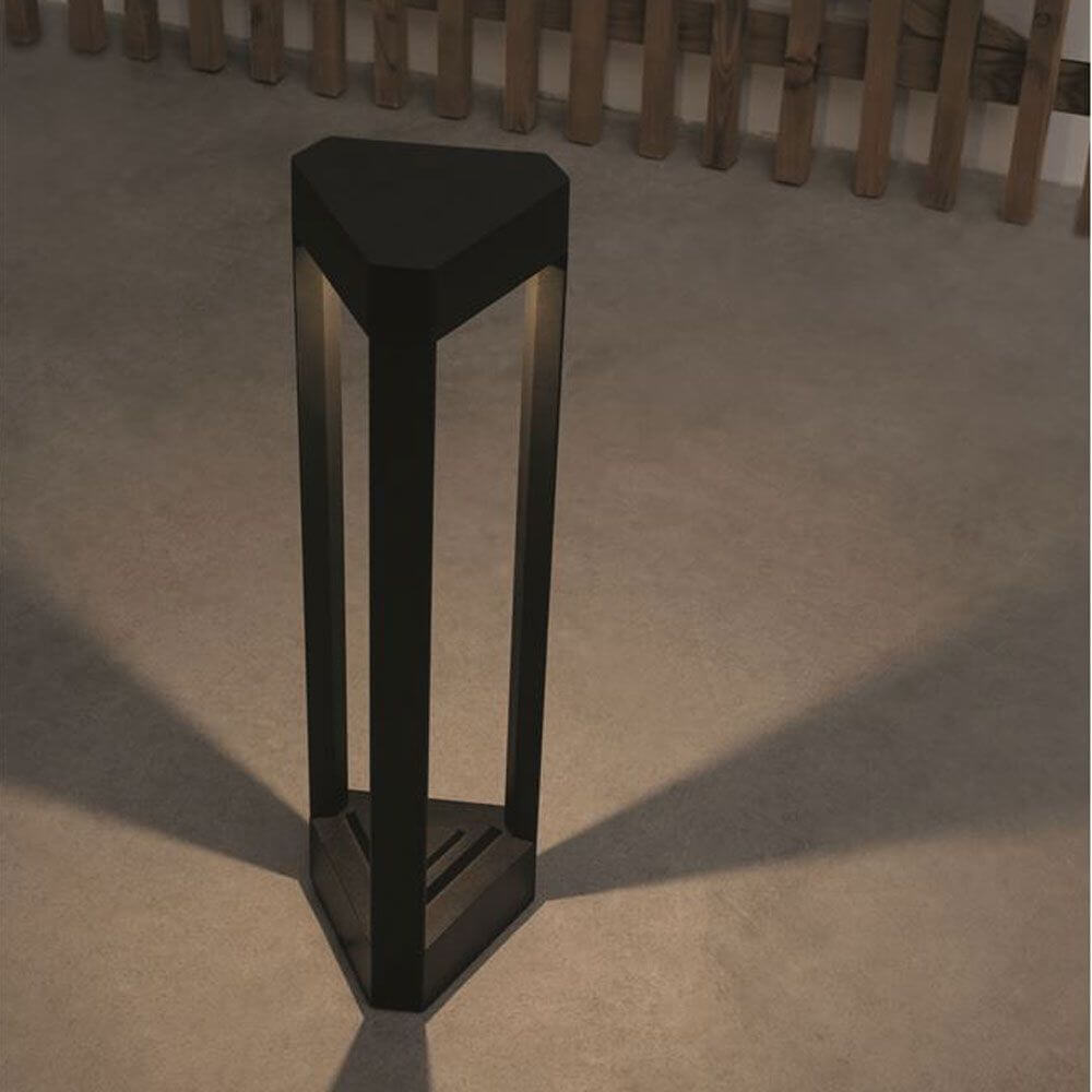 Pax Pollerleuchte Dreieck LED Schwarz auf einem Boden mit sanfter Beleuchtung und eleganter Form.
