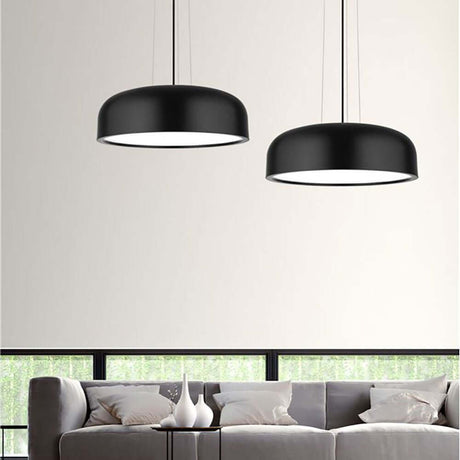 Moderne Perleto Pendelleuchte in Schwarz über einem stilvollen Sofa im Ess- und Wohnzimmer.