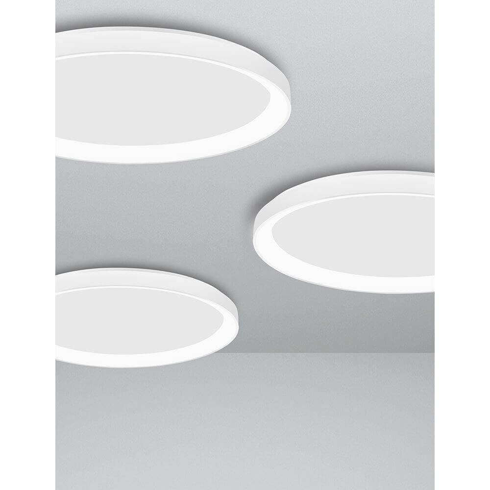 Schlichte Pertino LED Deckenlampe Ø 48cm Weiß in einem modernen Wohnraum, mit drei runden, weißen Leuchten.