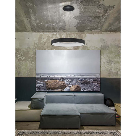Suspension intelligente moderne Rando LED au-dessus d’un espace de vie convivial au mobilier minimaliste.
