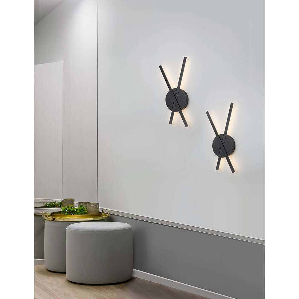 Zwei Reslin LED Metall Wandleuchten in modernem Design an einer Wand, die warmweißes Licht spenden.