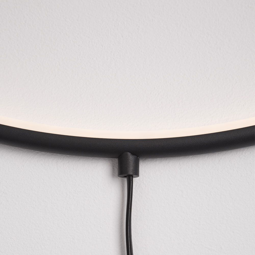 Ring LED-Wandleuchte zum aufhängen Schwarz - Detailansicht mit Kabel und Leuchte an Wand.