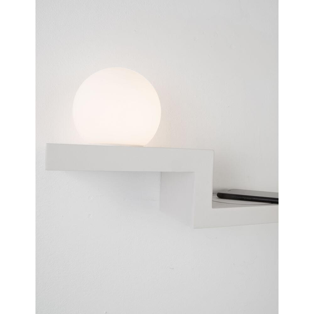Room LED Wandlampe mit Ladegerät auf einer modernen Wandablage, warmweißes Licht.