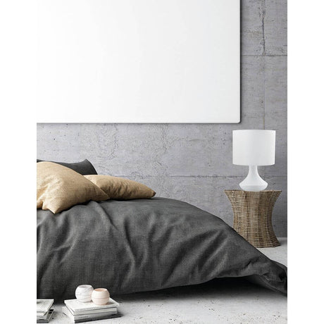 Rosia bordlampe mat hvid Ø 18cm på et natbord ved siden af en moderne seng og puder.