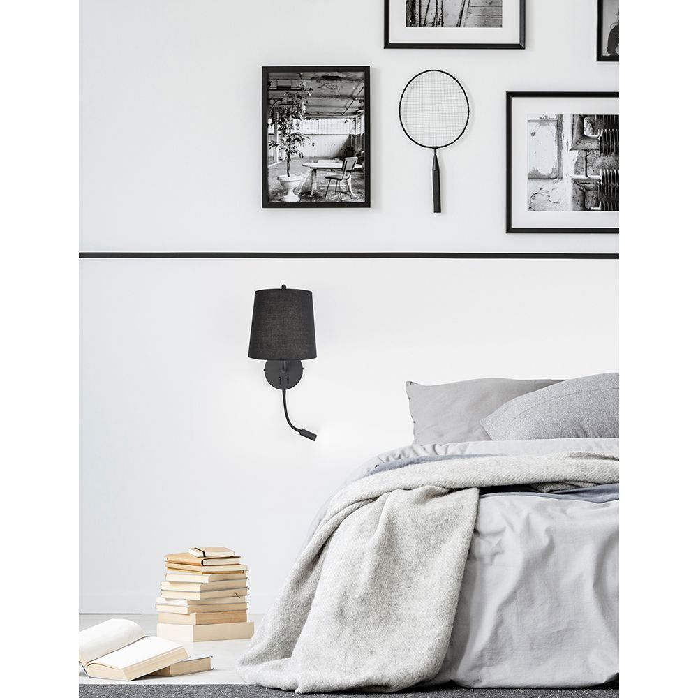 Sage Bett- & Wandlampe mit LED-Leselicht über einem Bett mit einer stylischen Bettwäsche und Bildern an der Wand.