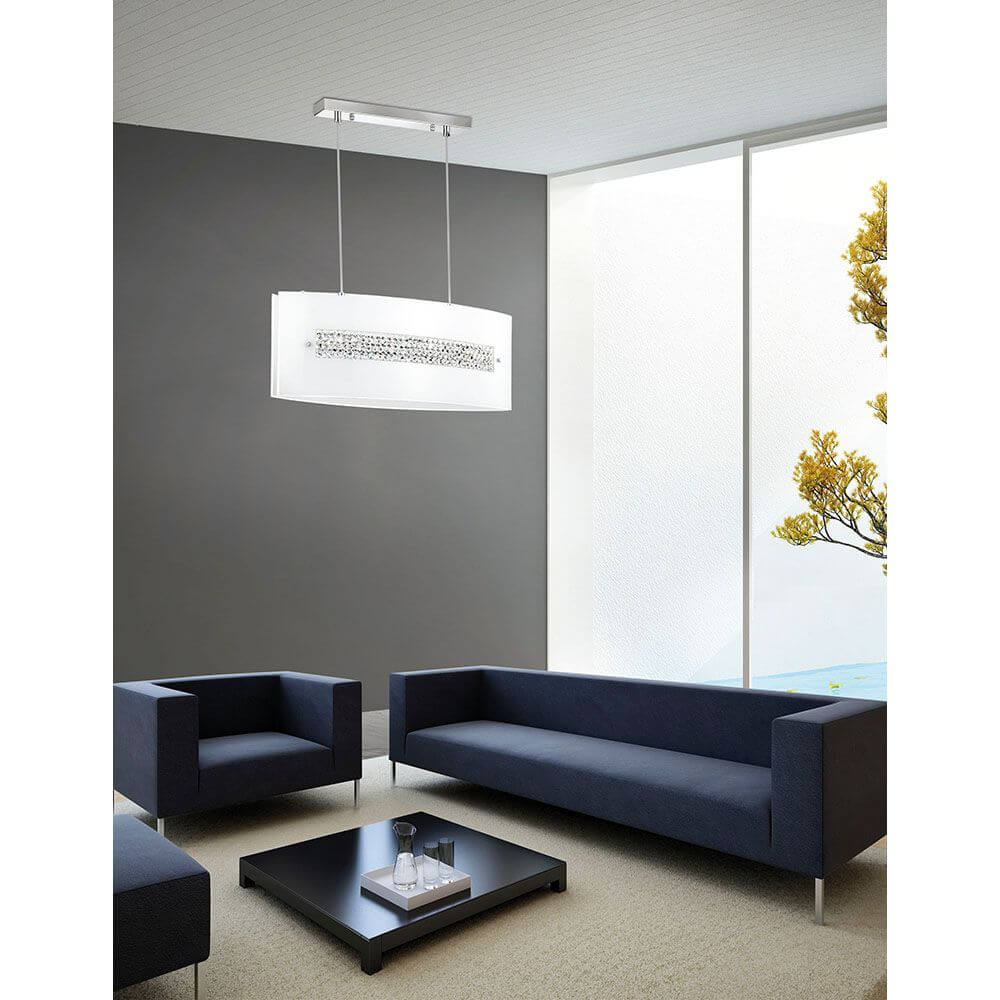 Thelta Hängeleuchte Kristall Chrom in modernem Wohnzimmer mit eleganten Sofas und natürlichem Licht.