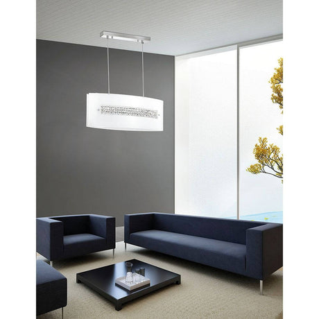 Thelta Hängeleuchte Kristall Chrom in modernem Wohnzimmer mit eleganten Sofas und natürlichem Licht.