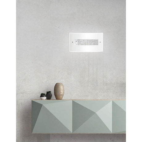 Thelta Wandlampe Glas Chrom an einer minimalistischen Wand, dekoriert mit einer modernen Vasen und geometrischem Möbel.