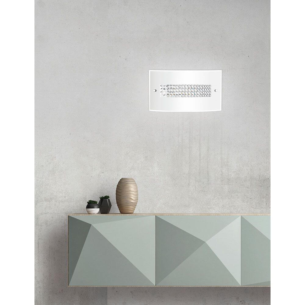 Thelta Wandlampe Glas Chrom an einer minimalistischen Wand, dekoriert mit einer modernen Vasen und geometrischem Möbel.