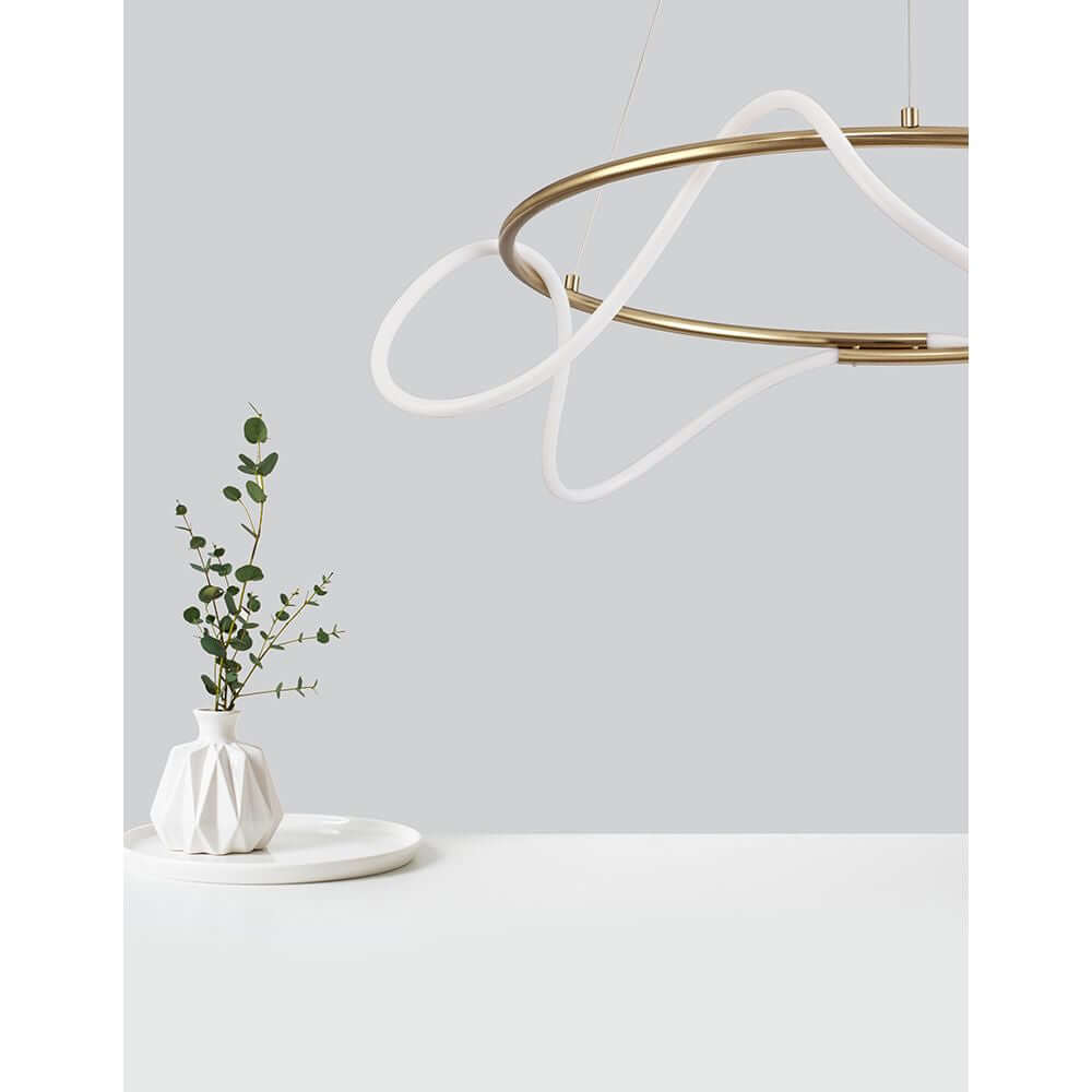 Tiriac LED Hängeleuchte Metall Ø 70cm über einem weißen Teller und einer Vase mit grüner Pflanze