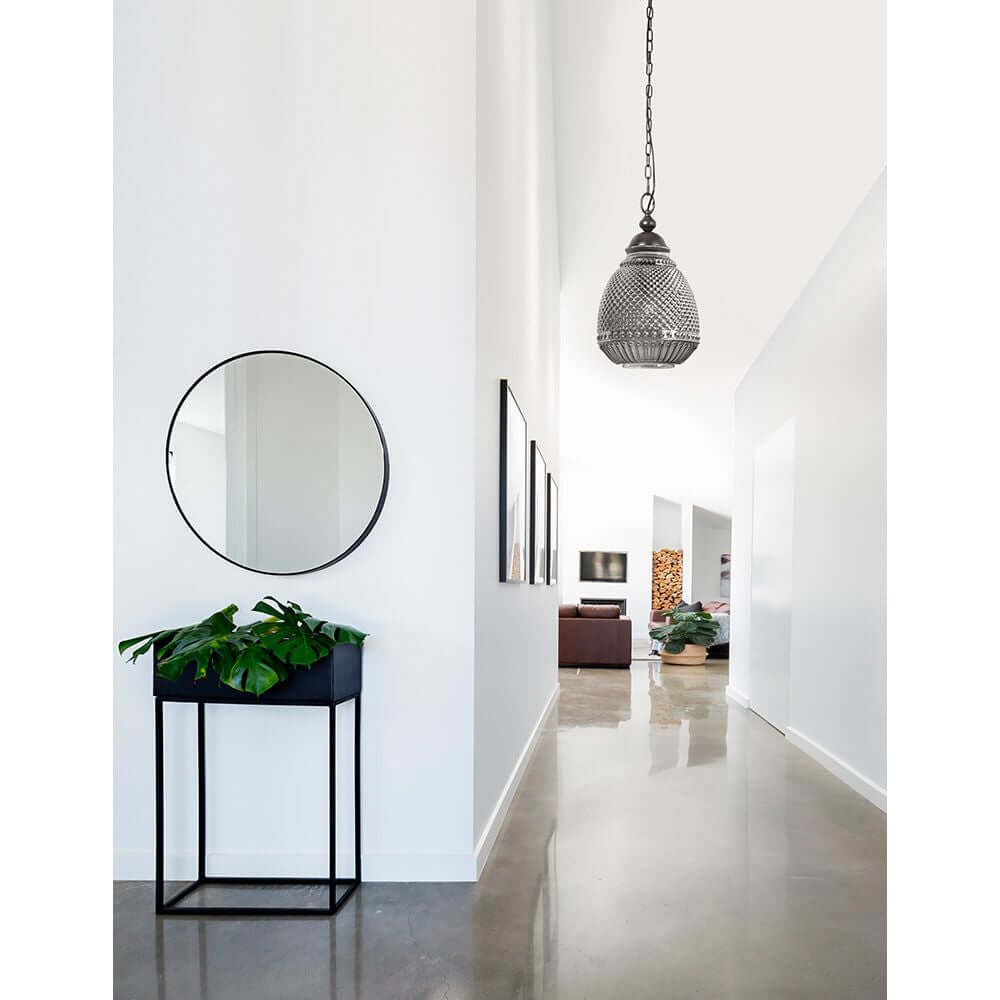 Toulon Glas-Pendellampe Metall an einer modernen weißen Wand im Flur mit Spiegel und Pflanzen.
