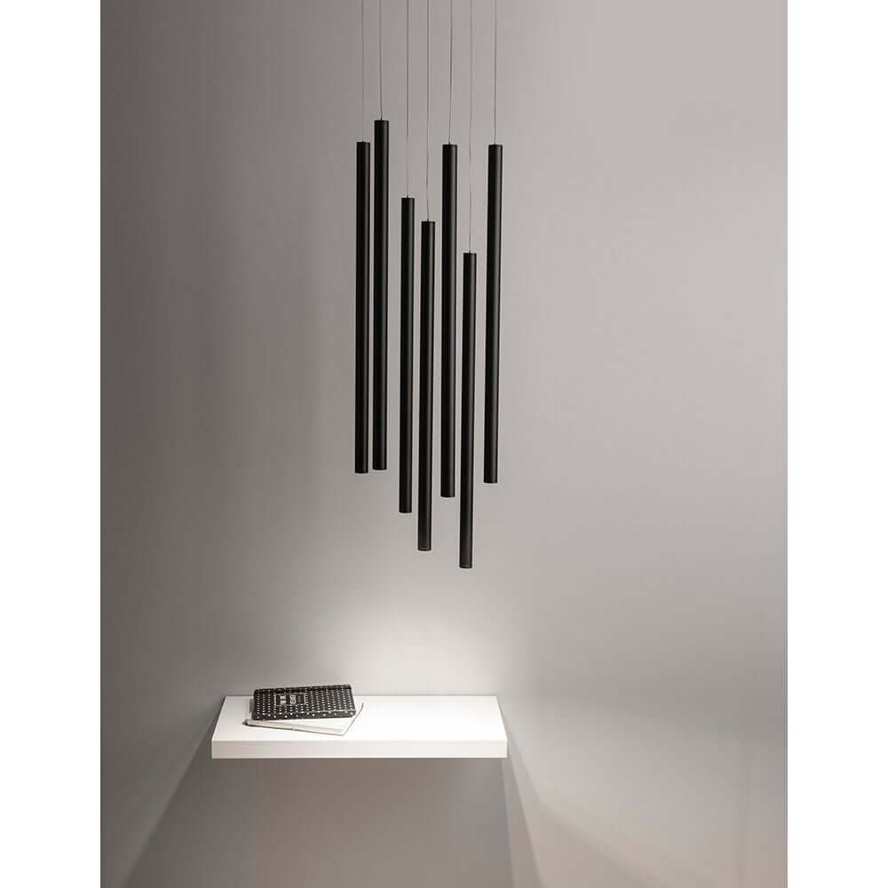 Ultrathin LED Hängeleuchte 7-flammig in modernem Design über einem Tisch mit schwarzem Notizbuch.