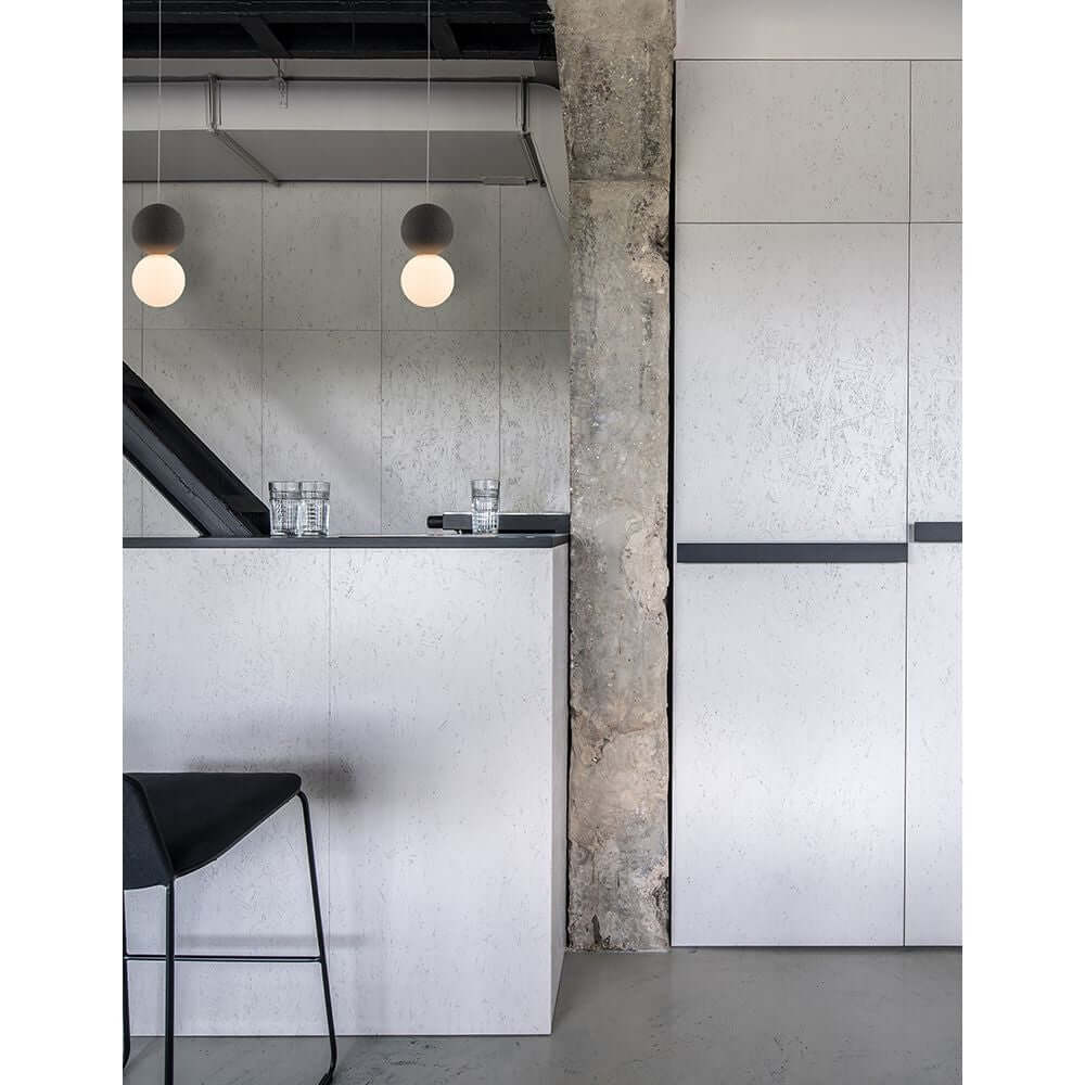 Zero Kugel Hängelampe Beton, Glas über modernem Essbereich mit minimalistischer Architektur.