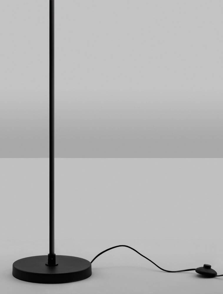 Nuvole LED Stehlampe 3000K Schwarz, Weiß auf schwarzem Boden mit Stromkabel und Fußschalter.