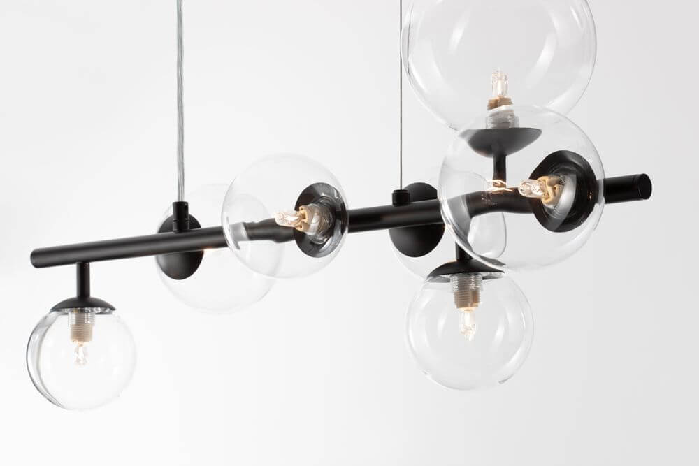 Odillia Pendelleuchte G9 7-flammig mit modernen Glaskugeln und schwarzem Metallarm.