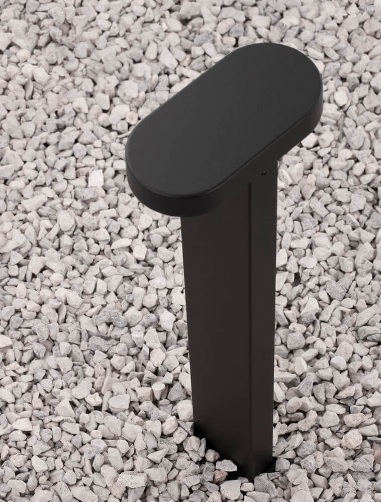 Moderne schwarze Wegeleuchte aus Aluminium, ideal für Garten und Terrasse, mit stabilem Stand auf Kies.